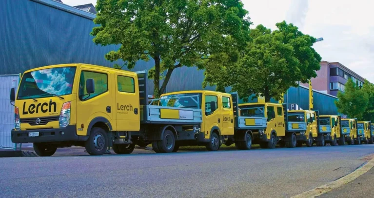 Eine Strasse auf der mehrere Lerch Lastwagen geparkt sind.